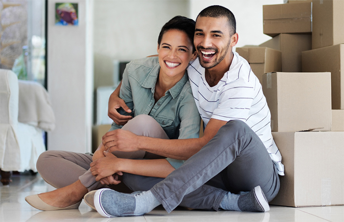 two people smiling while unpacking in a house